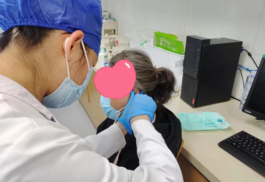 皮肤科护士为芳姨贴敷耳穴压豆.jpg